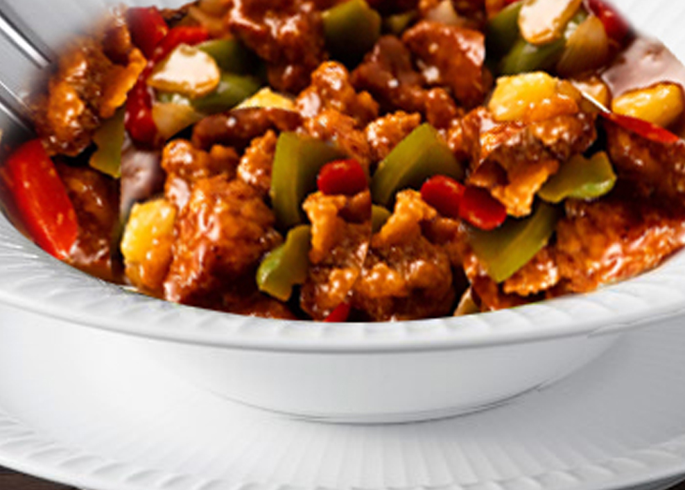 A bowl of food with meat and vegetables.