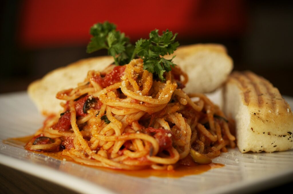 A plate of spaghetti with tomato sauce and parsley.