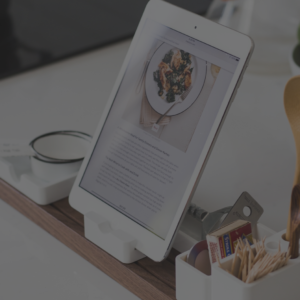 A tablet sitting on top of a wooden desk.