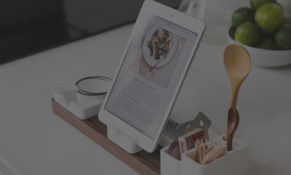 A tablet sitting on top of a wooden desk.