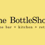 A yellow background with the words " the bottleshop " in black.